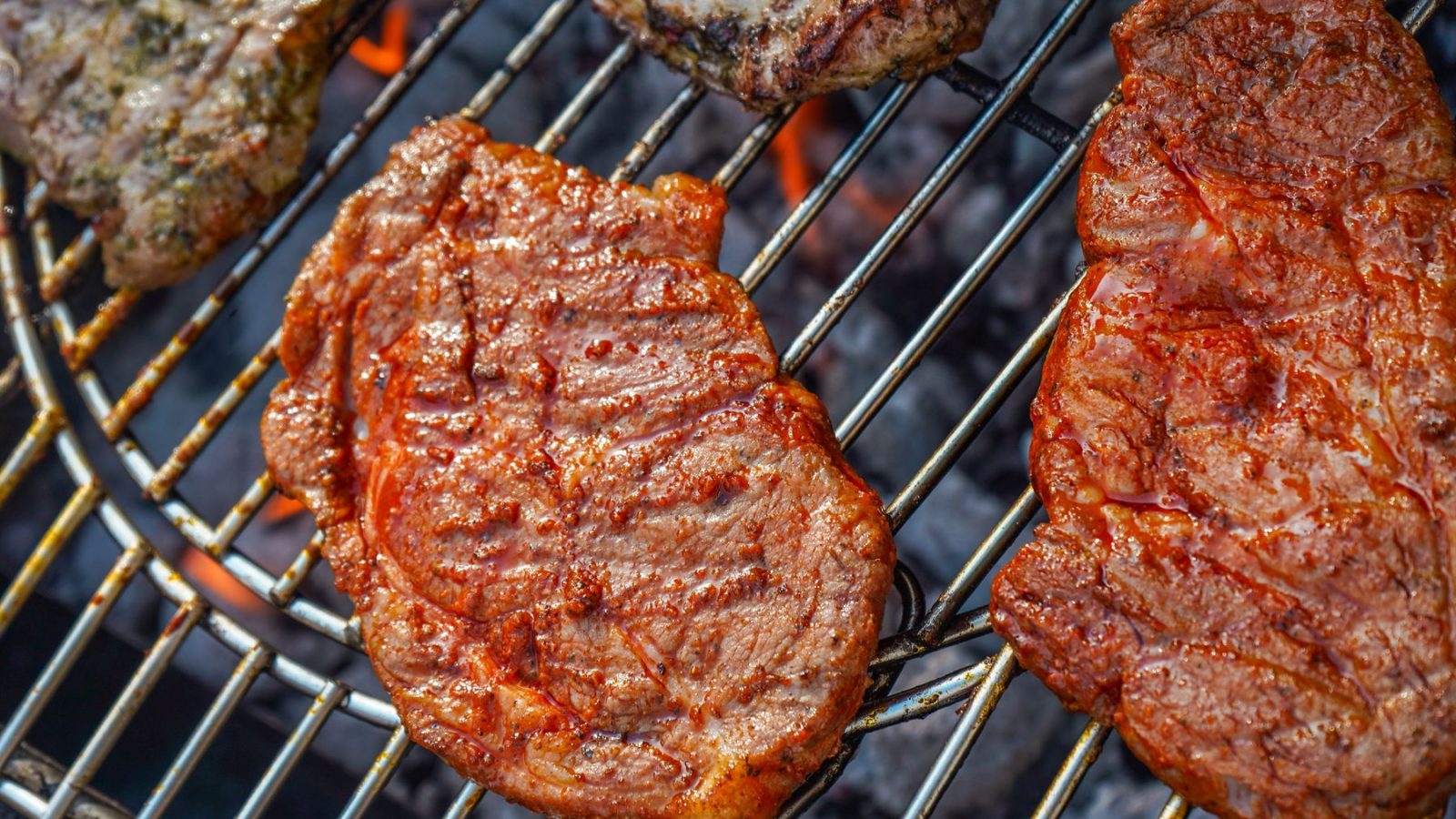 Steaks searing over an open oak fire